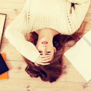 Gelassenheit lernen: Frau liegt gestresst auf dem Boden