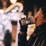 Frau trinkt Glühwein auf dem Weihnachtsmarkt